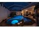 Backyard pool and spa area featuring elegant lighting and lush greenery, perfect for evening relaxation at 26089 Templar Ln, Punta Gorda, FL 33983