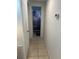 Hallway featuring tiled floors and leading to a full bathroom with Goofy themed bathmats and shower curtain at 3116 Crestwood Dr, Port Charlotte, FL 33952