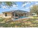 Spacious backyard with a screened pool, patio area, and lush green lawn for leisure at 312 Mendoza St, Punta Gorda, FL 33983