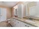 Bright bathroom featuring a double vanity with granite countertop and two framed mirrors at 312 Mendoza St, Punta Gorda, FL 33983