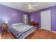 Comfortable bedroom with purple walls, featuring a full-sized bed, a window, and hardwood floors at 312 Mendoza St, Punta Gorda, FL 33983