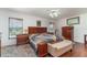 Spacious bedroom with a wooden sleigh bed, two windows, matching dressers, and a hardwood floor at 312 Mendoza St, Punta Gorda, FL 33983