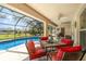 Relaxing screened-in patio features a dining set overlooking the beautiful pool and backyard at 312 Mendoza St, Punta Gorda, FL 33983