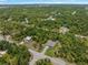 An aerial view showcases the home surrounded by lush greenery and a clear blue sky at 368 Manly St, Port Charlotte, FL 33953