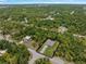 An aerial view showcases the home surrounded by lush greenery and a clear blue sky at 368 Manly St, Port Charlotte, FL 33953