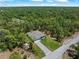 A high angle view features the home surrounded by lush greenery and a long driveway at 368 Manly St, Port Charlotte, FL 33953