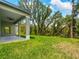 An expansive, green backyard with a covered patio and lush greenery at 368 Manly St, Port Charlotte, FL 33953