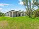 Expansive backyard featuring lush green grass, covered patio, and mature trees at 368 Manly St, Port Charlotte, FL 33953