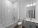 Modern bathroom featuring tiled walls, a soaking tub with a shower, and a vanity sink with cabinet at 368 Manly St, Port Charlotte, FL 33953