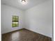 Bright bedroom with a window offering outdoor views, complemented by modern wood-style tiled flooring at 368 Manly St, Port Charlotte, FL 33953