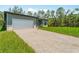 Expansive driveway leading to a well-maintained home with an attached garage and lush greenery at 368 Manly St, Port Charlotte, FL 33953