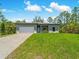 Charming home with a wide driveway, attached garage, and a green lawn under a bright sky at 368 Manly St, Port Charlotte, FL 33953