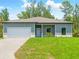 Single story home with neat lawn, a covered front porch, and an attached garage at 368 Manly St, Port Charlotte, FL 33953