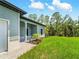Beautiful home exterior with a covered porch, green grass, and mature trees in the background at 368 Manly St, Port Charlotte, FL 33953