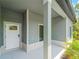 Close-up of a welcoming front porch with a white door, gray siding, and decorative columns at 368 Manly St, Port Charlotte, FL 33953
