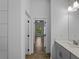 Bright hallway featuring tiled floors, open doorways, and a glimpse into the well-lit bedroom and bathroom at 368 Manly St, Port Charlotte, FL 33953