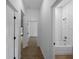 Bright hallway showcasing wood-style tiled floors, access to rooms, and a glimpse of the bathroom and bedroom at 368 Manly St, Port Charlotte, FL 33953