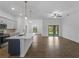Open floor plan with tile flooring showcases the modern kitchen, dining area, and backyard access at 368 Manly St, Port Charlotte, FL 33953