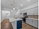 Modern kitchen features gray cabinets, stainless appliances, and quartz countertops with a stylish island and pendant lighting at 368 Manly St, Port Charlotte, FL 33953