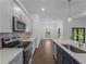 Modern kitchen with grey cabinets, stainless appliances, and a tile backsplash provides a sleek and functional cooking space at 368 Manly St, Port Charlotte, FL 33953