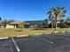 Community pool surrounded by palm trees and lush greenery near parking spaces at 4072 Oakview Dr # C5, Punta Gorda, FL 33980