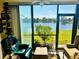 The sunroom features comfortable seating, a scenic lake view, and sliding glass doors at 4072 Oakview Dr # C5, Punta Gorda, FL 33980
