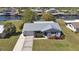 Aerial view of a cozy home with a metal roof, lush landscaping, and waterfront access, showcasing its prime location at 4091 Rock Creek Dr, Port Charlotte, FL 33948