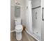 Bathroom with walk-in shower, toilet, and wood look flooring at 4091 Rock Creek Dr, Port Charlotte, FL 33948