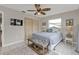 Bedroom with wooden closet doors, tile floors, bed and ceiling fan at 4091 Rock Creek Dr, Port Charlotte, FL 33948