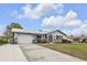 Attractive single-story home with a metal roof, landscaped front yard, and a spacious driveway leading to the garage at 4091 Rock Creek Dr, Port Charlotte, FL 33948