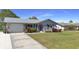 Well-maintained home featuring a metal roof, blue shutters, a concrete driveway and a manicured lawn at 4091 Rock Creek Dr, Port Charlotte, FL 33948