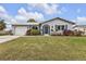 Charming home featuring a well-manicured lawn with mature landscaping and an attached garage at 4091 Rock Creek Dr, Port Charlotte, FL 33948