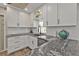 Stylish kitchen showcasing white cabinets, granite countertops, and modern hardware, complemented by contemporary finishes at 4091 Rock Creek Dr, Port Charlotte, FL 33948