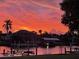 Stunning waterfront property featuring a dock and boat lift under a beautiful vivid sunset at 4091 Rock Creek Dr, Port Charlotte, FL 33948