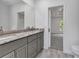 Bathroom featuring a granite vanity and double sinks, adjacent to a bedroom at 535 Milus St, Punta Gorda, FL 33950