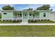 Charming mint green home with well-maintained lawn and beautiful landscaping at 535 Milus St, Punta Gorda, FL 33950