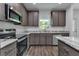 A close up of the modern kitchen featuring stainless steel appliances and stone countertops at 535 Milus St, Punta Gorda, FL 33950