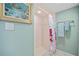 Bright bathroom featuring a walk-in shower with tiled walls and colorful shower curtain at 601 Shreve St # 62A, Punta Gorda, FL 33950
