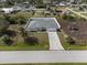 Aerial view of a single-story home with a spacious yard and a long driveway at 7095 Beardsley St, Englewood, FL 34224