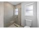 Modern bathroom features neutral tile in glass enclosed shower and toilet at 7095 Beardsley St, Englewood, FL 34224