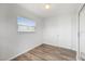 Cozy bedroom with wood-look floors, a window with blinds, and paneled walls at 7095 Beardsley St, Englewood, FL 34224