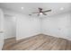 Bright bedroom featuring wood-look floors, ceiling fan, and neutral color palette at 7095 Beardsley St, Englewood, FL 34224