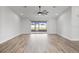 Spacious bedroom featuring updated flooring, a ceiling fan, and sliding glass doors leading to the lanai at 7095 Beardsley St, Englewood, FL 34224