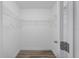Walk-in closet featuring metal shelving, white walls and wood-look floor at 7095 Beardsley St, Englewood, FL 34224