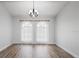 Formal dining room boasting wood-look floors, elegant chandelier, and natural light at 7095 Beardsley St, Englewood, FL 34224