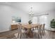Bright dining room featuring hardwood floors, a modern chandelier, and abundant natural light at 7095 Beardsley St, Englewood, FL 34224