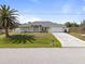 Well-maintained single Gathering home featuring lush lawn, mature landscaping, and an attached garage at 7095 Beardsley St, Englewood, FL 34224