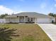 Charming single-story home featuring a well-maintained lawn, double door entrance, and attached two-car garage at 7095 Beardsley St, Englewood, FL 34224