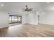 Bright living room featuring updated flooring, a ceiling fan, and sliding glass doors leading to the lanai at 7095 Beardsley St, Englewood, FL 34224