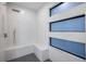 Modern bathroom with sleek tiling, a built-in bench, and horizontal picture windows at 9493 St Paul Dr, Port Charlotte, FL 33981